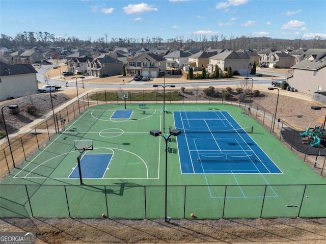 exterior space featuring a residential view, community basketball court, and fence