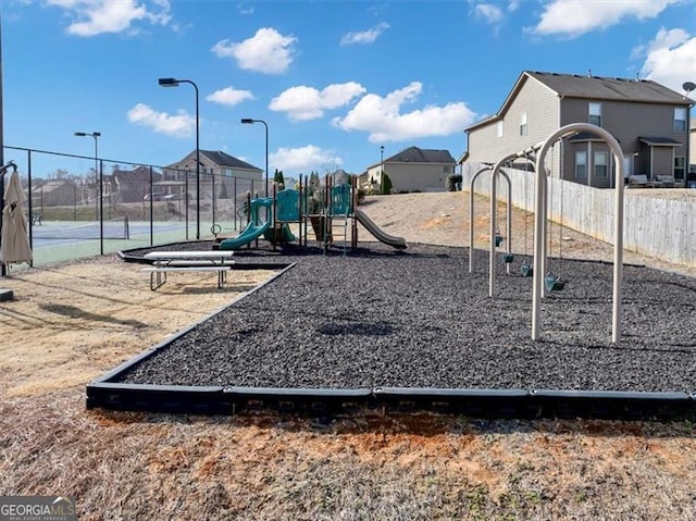 community play area featuring fence and a residential view