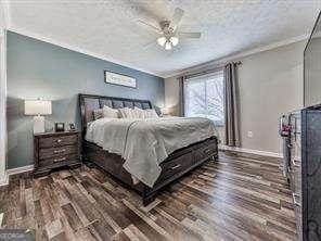 bedroom featuring a ceiling fan, baseboards, and wood finished floors