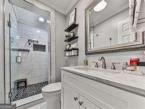 full bathroom featuring a stall shower, toilet, and vanity