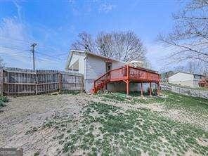 back of house with stairway, a wooden deck, and a fenced backyard