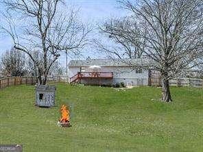 view of yard featuring an outbuilding, fence, and an outdoor fire pit