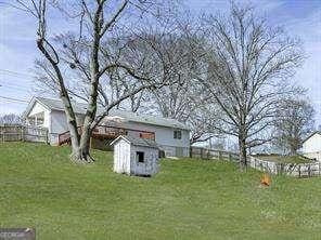 view of yard featuring a storage shed, an outbuilding, and fence