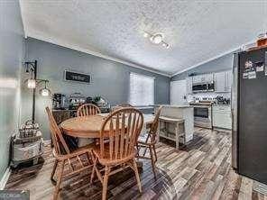 dining area with lofted ceiling and wood finished floors