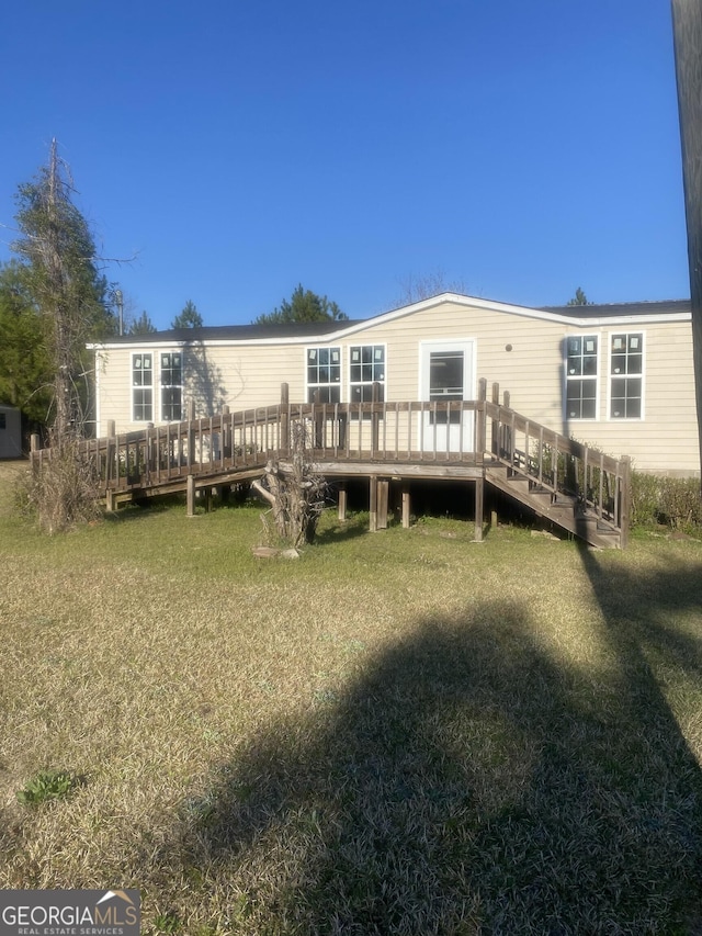 back of house featuring a yard and a deck