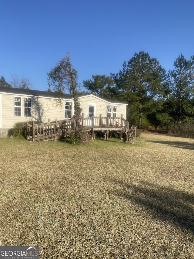 back of house with a deck and a lawn