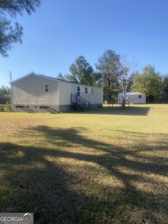 view of yard featuring entry steps and an outbuilding