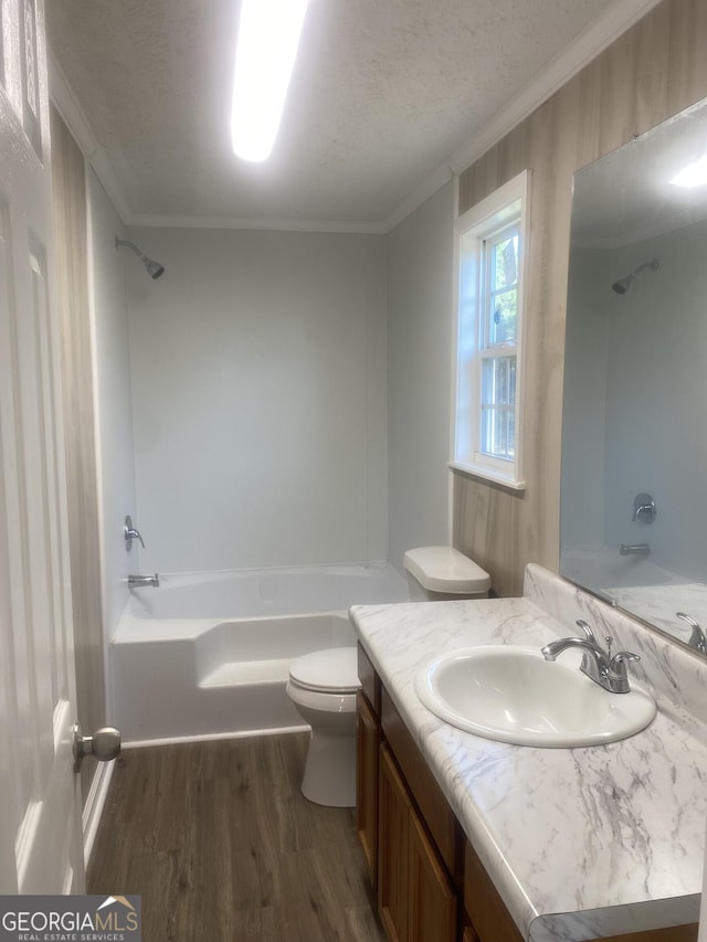 full bath with crown molding, toilet, bathing tub / shower combination, wood finished floors, and vanity