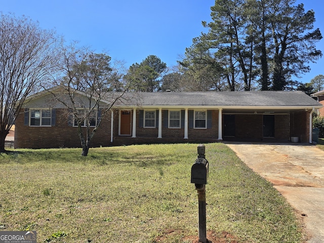 ranch-style house featuring a front yard, a carport, brick siding, and driveway