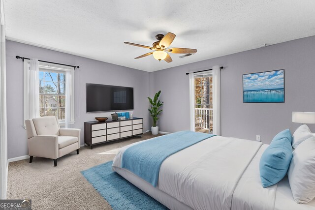 carpeted bedroom featuring a ceiling fan, baseboards, visible vents, and a textured ceiling