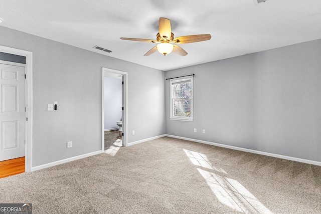 unfurnished bedroom with visible vents, ensuite bath, carpet, and baseboards