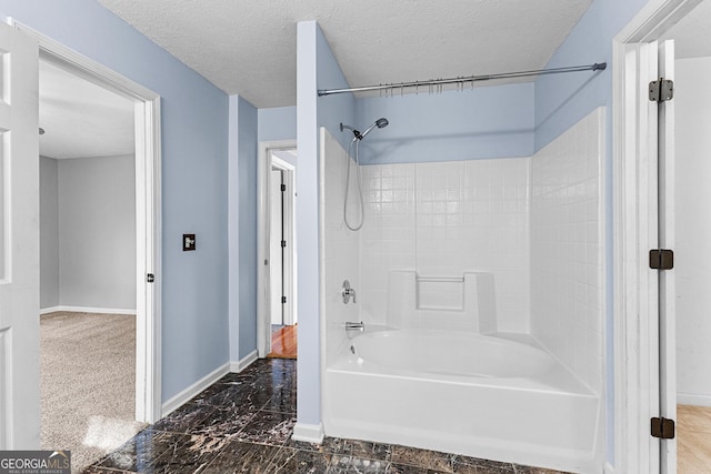 bathroom featuring baseboards, a textured ceiling, and bathtub / shower combination