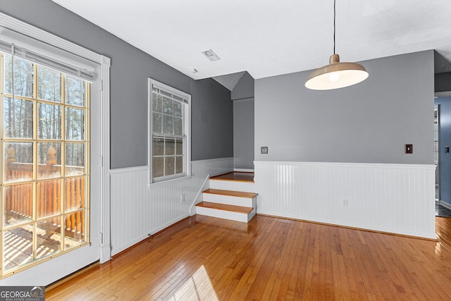 interior space with hardwood / wood-style floors, stairs, visible vents, and wainscoting