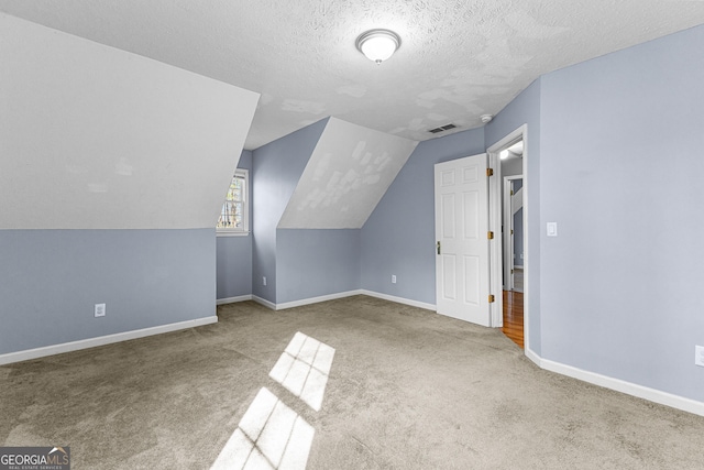 bonus room with visible vents, baseboards, lofted ceiling, carpet floors, and a textured ceiling