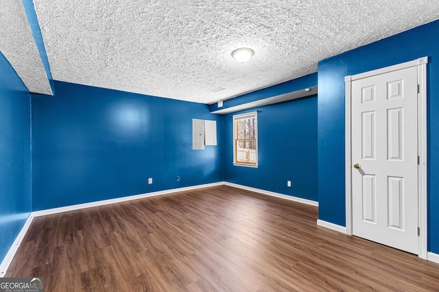 unfurnished bedroom with wood finished floors, baseboards, and a textured ceiling