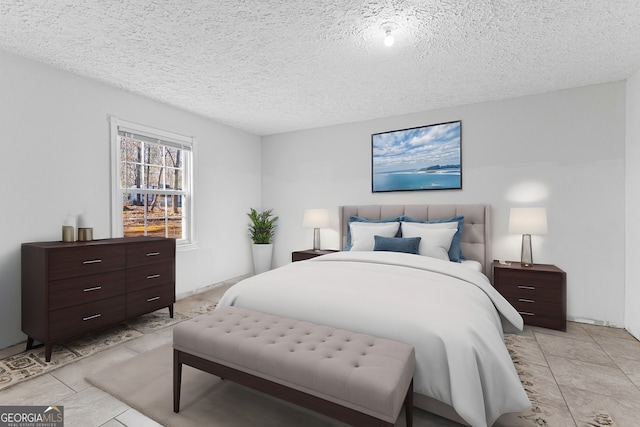 bedroom with light tile patterned flooring and a textured ceiling