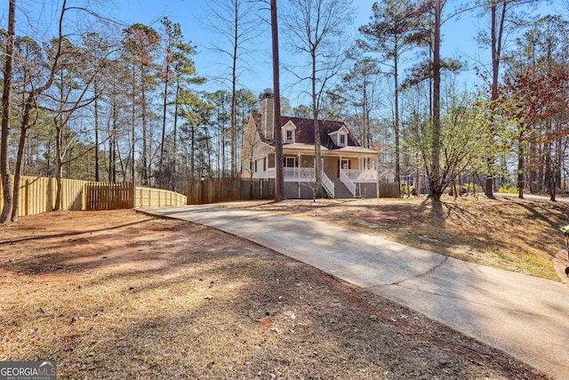 exterior space with a porch, a chimney, and fence