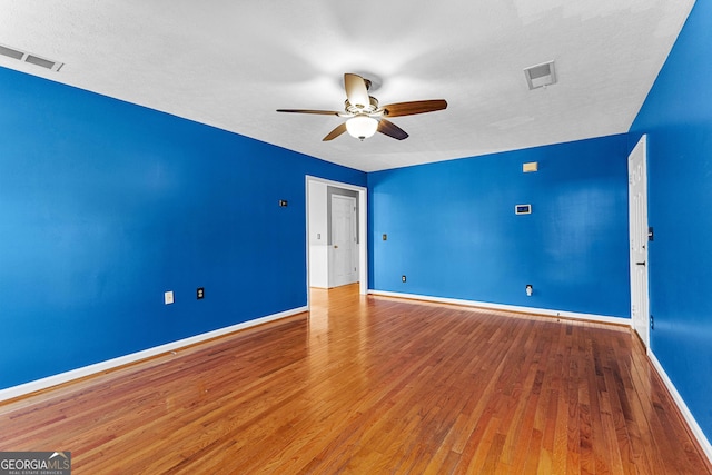 empty room with visible vents, baseboards, a ceiling fan, and wood finished floors