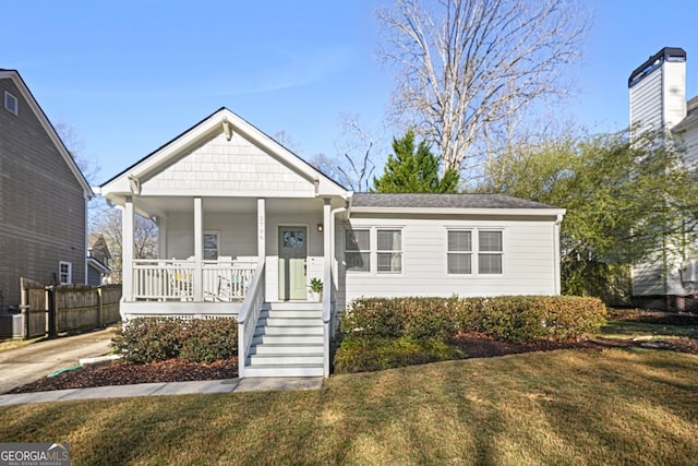 view of front facade with central air condition unit, covered porch, a front lawn, and fence