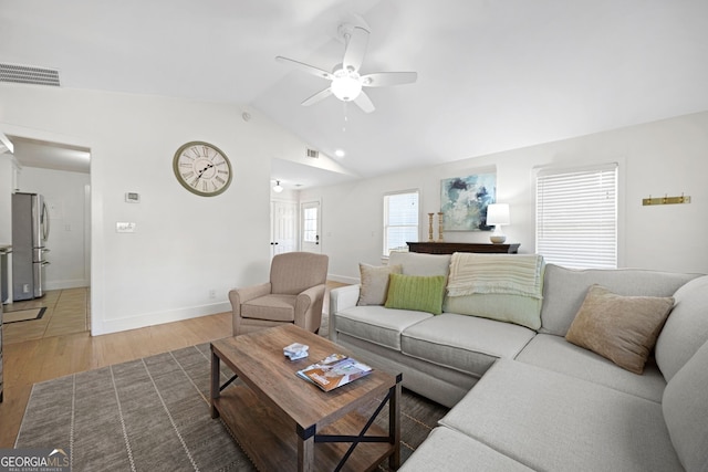 living room with visible vents, light wood-style flooring, ceiling fan, and vaulted ceiling