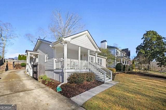 bungalow-style home featuring covered porch and a front yard