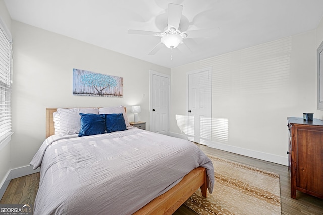 bedroom with ceiling fan, baseboards, and wood finished floors