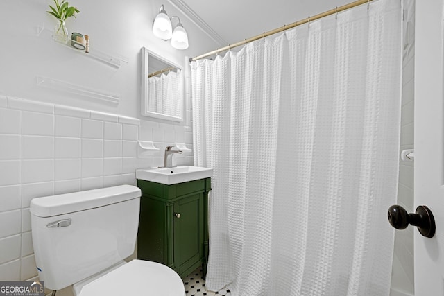 bathroom featuring vanity, tile walls, toilet, and a wainscoted wall