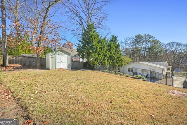 view of yard featuring an outbuilding, a storage unit, and a fenced backyard