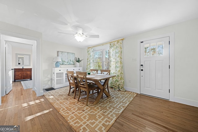 dining room with light wood-style flooring, baseboards, and ceiling fan