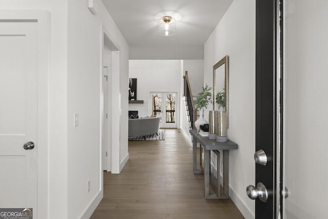 corridor featuring baseboards and wood finished floors