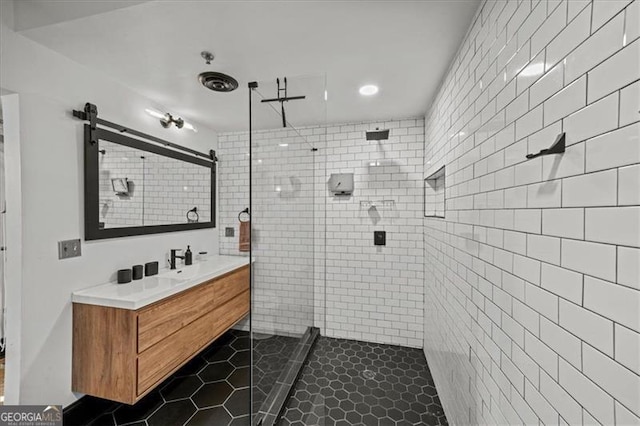 bathroom with a tile shower, tile patterned flooring, and vanity