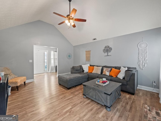 living room with visible vents, baseboards, light wood-style floors, and a ceiling fan