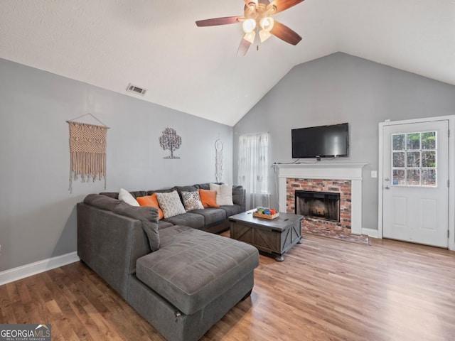 living room with visible vents, baseboards, light wood finished floors, lofted ceiling, and ceiling fan