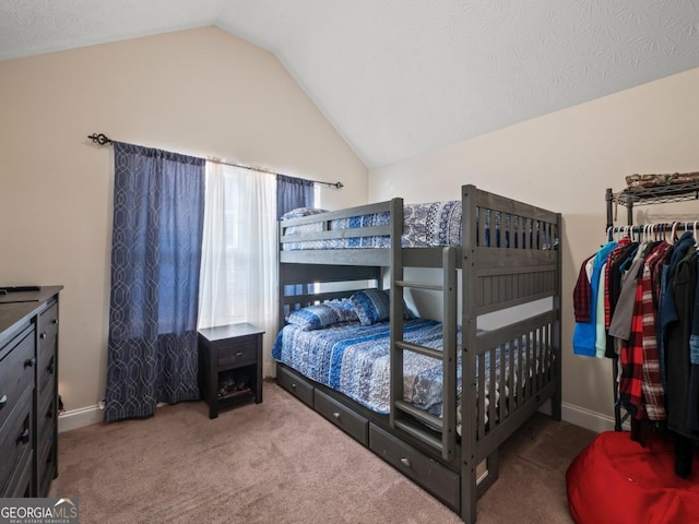 bedroom with lofted ceiling, carpet, and baseboards