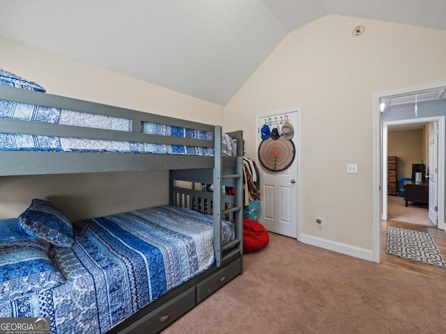 bedroom with lofted ceiling, attic access, carpet flooring, and baseboards