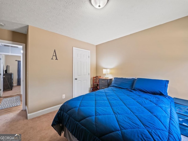 carpeted bedroom featuring baseboards and a textured ceiling