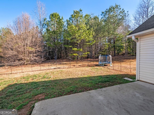 view of yard with a patio, a trampoline, and fence