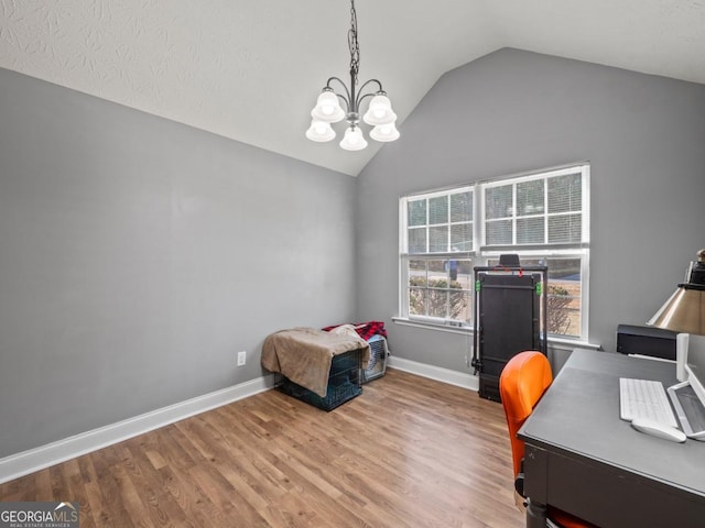 unfurnished office with baseboards, lofted ceiling, a notable chandelier, and wood finished floors