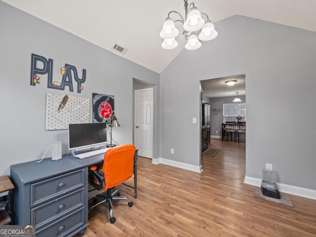 home office with light wood-style floors, visible vents, lofted ceiling, and a notable chandelier