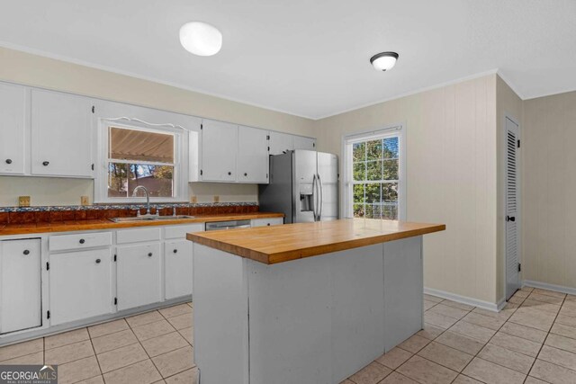 kitchen featuring a sink, wood counters, appliances with stainless steel finishes, and white cabinets