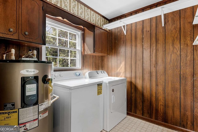 laundry area featuring water heater, cabinet space, light floors, and washing machine and clothes dryer