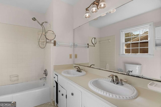 bathroom with double vanity, shower / washtub combination, toilet, and a sink