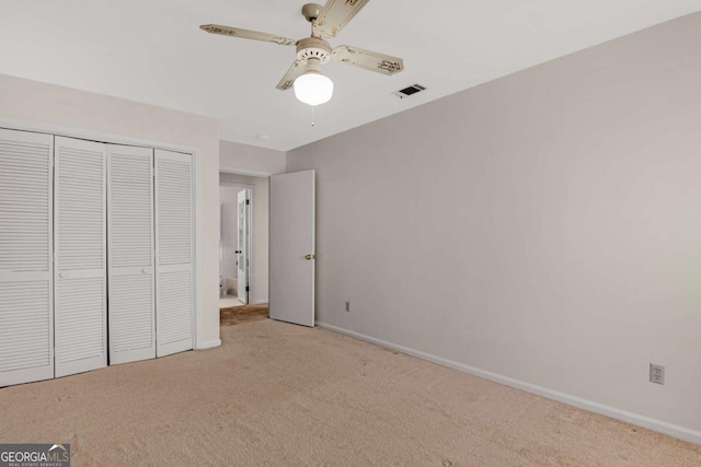 unfurnished bedroom featuring visible vents, baseboards, a closet, and carpet flooring