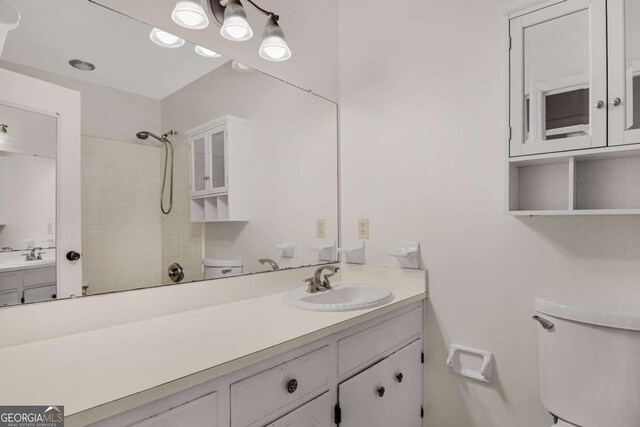 full bathroom featuring a shower, toilet, and vanity