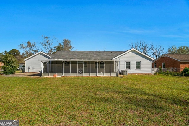 rear view of house featuring central AC, a yard, and a sunroom