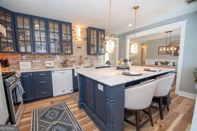 kitchen featuring blue cabinetry, a kitchen island, dishwasher, and stainless steel range with gas stovetop