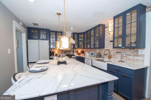 kitchen featuring white appliances, blue cabinets, glass insert cabinets, and a sink