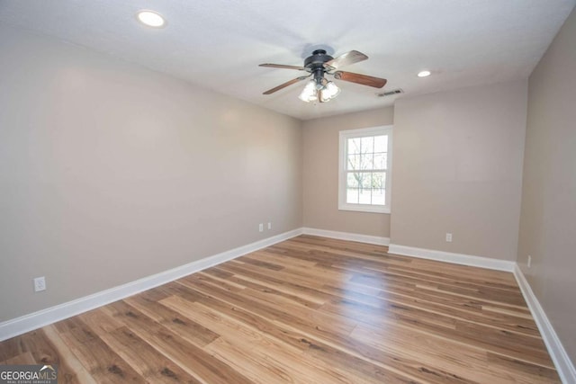 spare room featuring ceiling fan, baseboards, visible vents, and light wood-type flooring