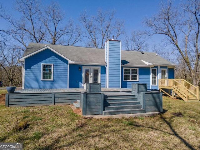 rear view of property featuring french doors, a lawn, a deck, and a chimney