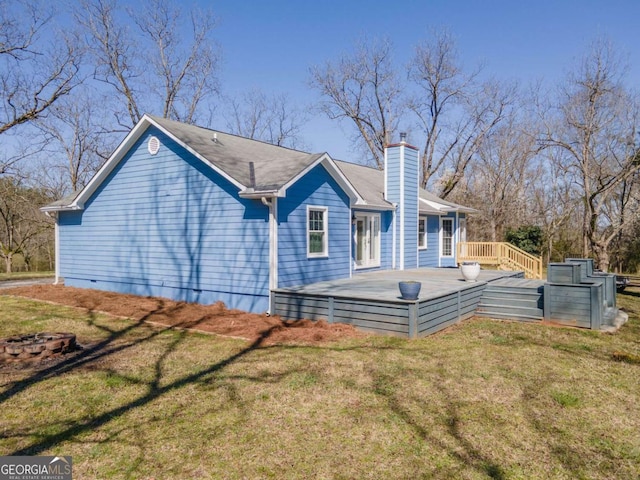 rear view of house featuring crawl space, a lawn, a deck, and a chimney